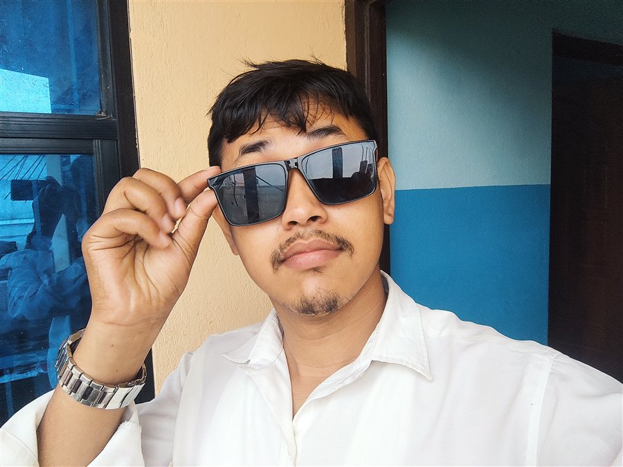 Amin Nepali wearing sunglasses and a white shirt